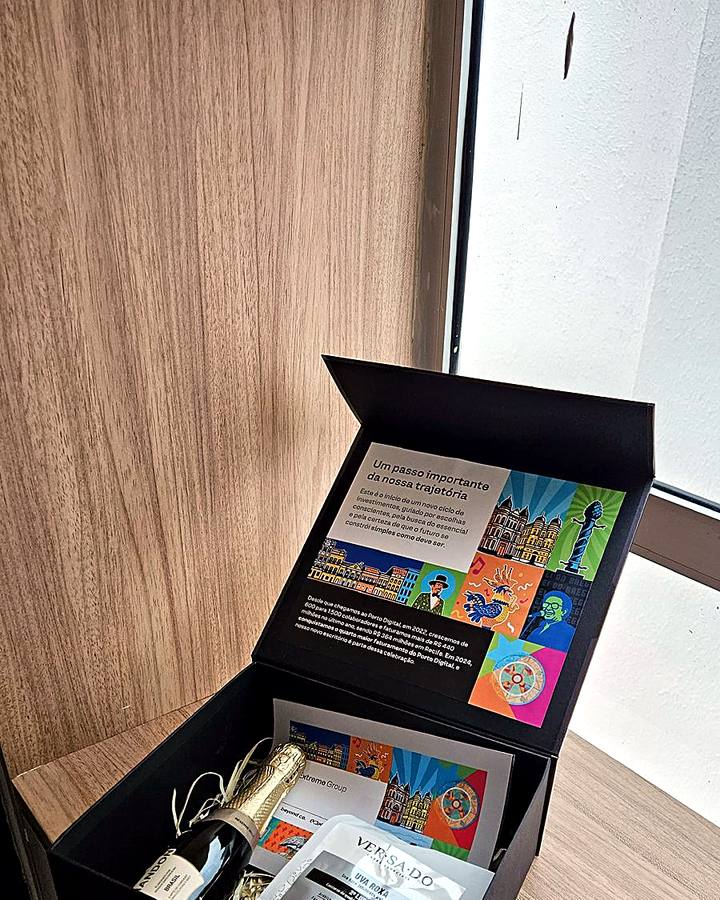Kit corporativo de aniversário Extreme Group, com espumante e cards ilustrados do Porto Digital